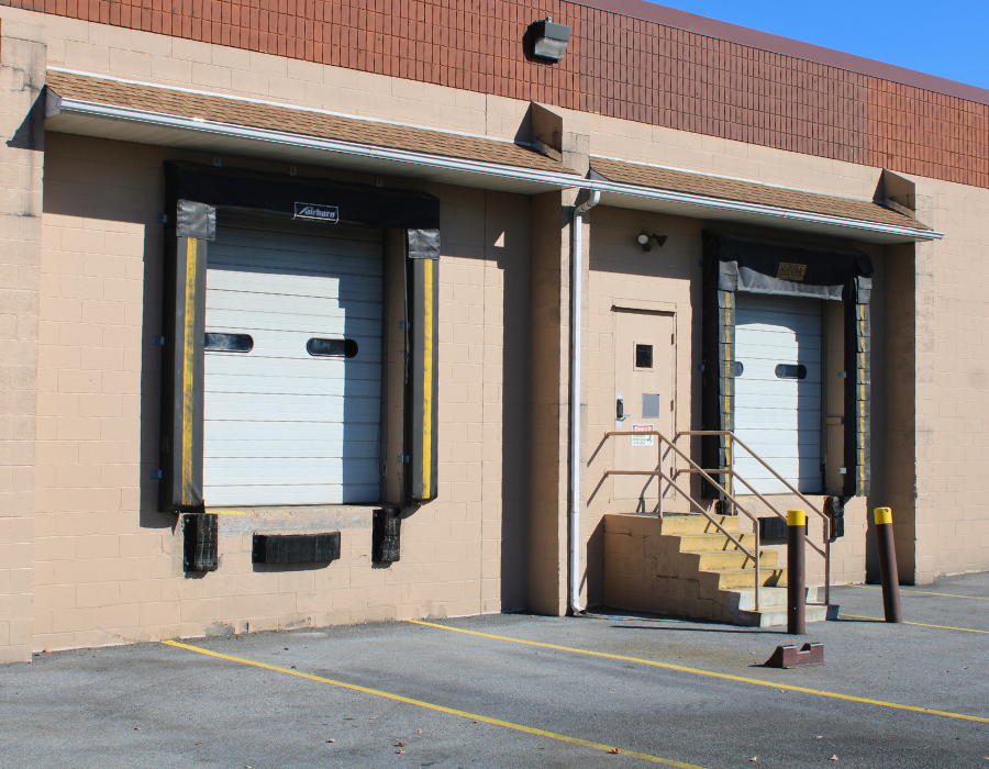 Two loading docks on the side of a tan building