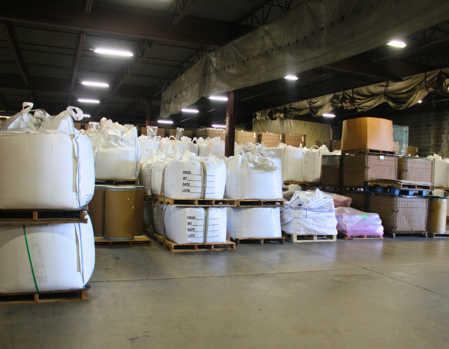 Pallets of white bags and boxes of sand for foundries inside a warehouse