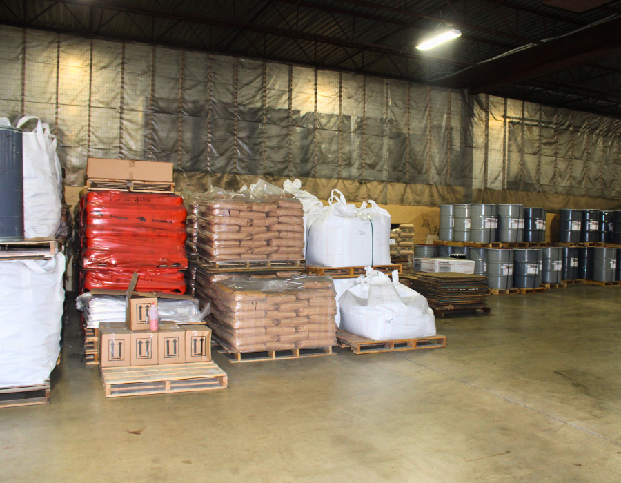 Pallets of drums, bags, and boxes of foundry supplies inside a warehouse